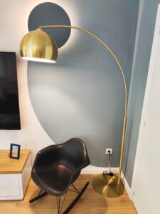 Fauteuil design, lampadaire doré et mur artistique, coin détente La-Forge Toulouse.