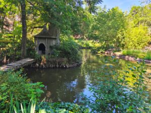 Petit ponton en bois menant à une cabane au bord d'un étang, Jardin des Plantes Toulouse.